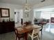 Cozy dining area featuring a classic chandelier and wood table adjacent to a living area at 10308 Fore Dr, Tampa, FL 33612