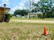 A spacious front yard with trees and a two-story home with a light-colored exterior and a visible two-car garage at 10308 Fore Dr, Tampa, FL 33612