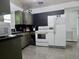 A view of the kitchen with black back splash, grey cabinetry, and white appliances at 10308 Fore Dr, Tampa, FL 33612