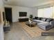 Bright living room with a gray sectional sofa, patterned rug, and decorative accents at 10308 Fore Dr, Tampa, FL 33612