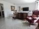 Bright living room featuring terrazzo floors, classic furnishings, and a view into the kitchen at 10308 Fore Dr, Tampa, FL 33612