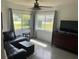 Living room with large windows, a ceiling fan, and a large dresser at 10308 Fore Dr, Tampa, FL 33612