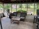 Relaxing screened patio featuring tiled floors and comfortable wicker furniture at 10308 Fore Dr, Tampa, FL 33612
