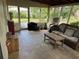 Relaxing screened porch with wicker seating, offering a serene view of the outdoor surroundings at 10308 Fore Dr, Tampa, FL 33612