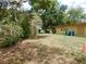 A spacious grassy yard next to a yellow building with exterior details and trees under a bright sunny sky at 10308 Fore Dr, Tampa, FL 33612