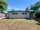 View of the home's backyard, showing the building's exterior, blue trim, and partial fencing at 10367 109Th Ave, Largo, FL 33773