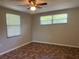 Bright bedroom featuring multiple windows, a ceiling fan, and unique tile-patterned flooring at 10367 109Th Ave, Largo, FL 33773