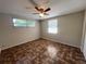 Bright bedroom featuring multiple windows, a ceiling fan, and unique tile-patterned flooring at 10367 109Th Ave, Largo, FL 33773