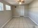 This bedroom is bright, with tiled floor, neutral paint, and a private entrance door to the outside at 10367 109Th Ave, Largo, FL 33773