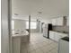 The kitchen features tiled floors, a center serving counter, and stainless steel refrigerator, and bright lighting at 10367 109Th Ave, Largo, FL 33773