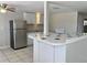 Functional kitchen with tiled floors, stainless steel refrigerator, and bright white cabinets, ready for culinary creations at 10367 109Th Ave, Largo, FL 33773