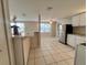 An open-concept kitchen includes tiled flooring, a center serving counter, and stainless steel refrigerator at 10367 109Th Ave, Largo, FL 33773