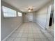 Bright living room with tile floors, ceiling fan, and two windows that fill the space with natural light at 10367 109Th Ave, Largo, FL 33773