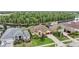 Aerial view of a yellow house with lush landscaping and a lake view at 10641 Cory Lake Dr, Tampa, FL 33647