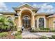 Stately yellow home showcasing an elegant entrance with beautiful columns at 10641 Cory Lake Dr, Tampa, FL 33647