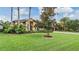 Well-manicured lawn with mature trees in front of a yellow home at 10641 Cory Lake Dr, Tampa, FL 33647