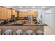 Open kitchen featuring wood cabinets, granite countertops, stainless steel appliances, and a breakfast bar with seating at 10641 Cory Lake Dr, Tampa, FL 33647