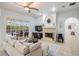 Light-filled living room with a fireplace, ceiling fan, and view of the screened outdoor patio at 10641 Cory Lake Dr, Tampa, FL 33647