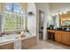 Luxurious main bathroom showcases a soaking tub with a glass block window and elegant fixtures at 10641 Cory Lake Dr, Tampa, FL 33647