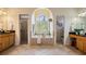 Relaxing main bathroom features a soaking tub, glass block window, and dual vanities at 10641 Cory Lake Dr, Tampa, FL 33647