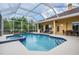 A lovely screened-in pool and spa are surrounded by lounge chairs and an outdoor dining area at 10641 Cory Lake Dr, Tampa, FL 33647