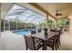 A lovely screened-in pool and spa are conveniently located next to an outdoor dining area with a ceiling fan at 10641 Cory Lake Dr, Tampa, FL 33647