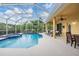 A lovely screened-in pool and spa are surrounded by lounge chairs and beautiful landscaping at 10641 Cory Lake Dr, Tampa, FL 33647