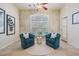 Cozy sitting area with comfortable blue chairs, plantation shutters, and natural light at 10641 Cory Lake Dr, Tampa, FL 33647
