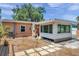 Spacious backyard features a stone walkway, a small patio, and an addition with an abundance of windows at 1117 Tyrone N Blvd, St Petersburg, FL 33710