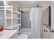 Cozy bathroom with gray tiled shower/tub combination, floating shelves, and updated fixtures and hardware at 1117 Tyrone N Blvd, St Petersburg, FL 33710