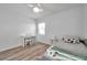 Comfortable bedroom with a ceiling fan, wood laminate floors, and a cozy daybed next to a small table at 1117 Tyrone N Blvd, St Petersburg, FL 33710