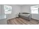 Bright bedroom with light wood floors, modern furniture, and two windows providing ample natural light at 1117 Tyrone N Blvd, St Petersburg, FL 33710