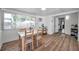 Bright dining room with table seating for four, wood flooring and natural light from large windows, with access to other rooms at 1117 Tyrone N Blvd, St Petersburg, FL 33710