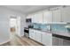Modern kitchen with granite countertops, white cabinets, and stainless-steel appliances at 1117 Tyrone N Blvd, St Petersburg, FL 33710