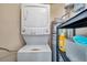 Utility room features a stacked washer and dryer set with additional shelving and adjacent water heater at 1117 Tyrone N Blvd, St Petersburg, FL 33710