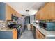 Functional kitchen with stainless steel appliances, warm wood cabinets and a stone countertop at 11486 92Nd N St, Largo, FL 33773