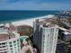 Stunning aerial view of beachfront property, white sands, and high-rise buildings, complete with lush landscaping and pools at 1180 Gulf Blvd # 306, Clearwater, FL 33767