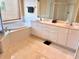 Bright bathroom featuring dual sinks, white cabinets, large soaking tub and window with blinds at 1180 Gulf Blvd # 306, Clearwater, FL 33767