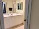 Bathroom vanity with double mirrors and white cabinetry offers ample storage space at 1180 Gulf Blvd # 306, Clearwater, FL 33767