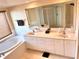 Bright bathroom with double vanity, soaking tub, walk-in shower, and large mirror at 1180 Gulf Blvd # 306, Clearwater, FL 33767