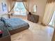 Comfortable bedroom with stylish grey headboard, blue comforter, desk and tiled flooring at 1180 Gulf Blvd # 306, Clearwater, FL 33767