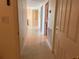 Bright hallway featuring tile flooring and neutral walls leads to various rooms in the home at 1180 Gulf Blvd # 306, Clearwater, FL 33767