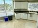Modern kitchen featuring white cabinets, dark countertops, and a view through the windows at 1180 Gulf Blvd # 306, Clearwater, FL 33767