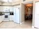 Bright kitchen with white cabinets, modern appliances, and adjacent dining area at 1180 Gulf Blvd # 306, Clearwater, FL 33767