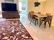 Open living area with tile floors, dining table, and a flat screen TV with storage underneath at 1180 Gulf Blvd # 306, Clearwater, FL 33767