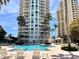 Inviting pool area with lounge chairs and umbrellas, set amidst high-rise buildings and lush landscaping at 1180 Gulf Blvd # 306, Clearwater, FL 33767