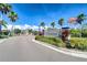 Community entrance featuring manicured landscaping, palm trees and an American flag at 1210 Harbour Blue St, Ruskin, FL 33570