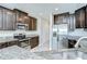 Well-lit kitchen featuring granite countertops, stainless steel appliances, and dark wood cabinets at 1210 Harbour Blue St, Ruskin, FL 33570