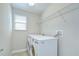 Functional laundry area with modern washer and dryer, wire shelving, and natural light at 1210 Harbour Blue St, Ruskin, FL 33570