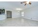 Spacious living room with tile flooring and ceiling fan transitioning to a kitchen with dark wood cabinetry at 1210 Harbour Blue St, Ruskin, FL 33570